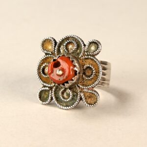 Antico anello berbero in argento decorato con residui di smalto giallo e verde, con perlina di corallo antico incastonata al centro della parte anteriore.